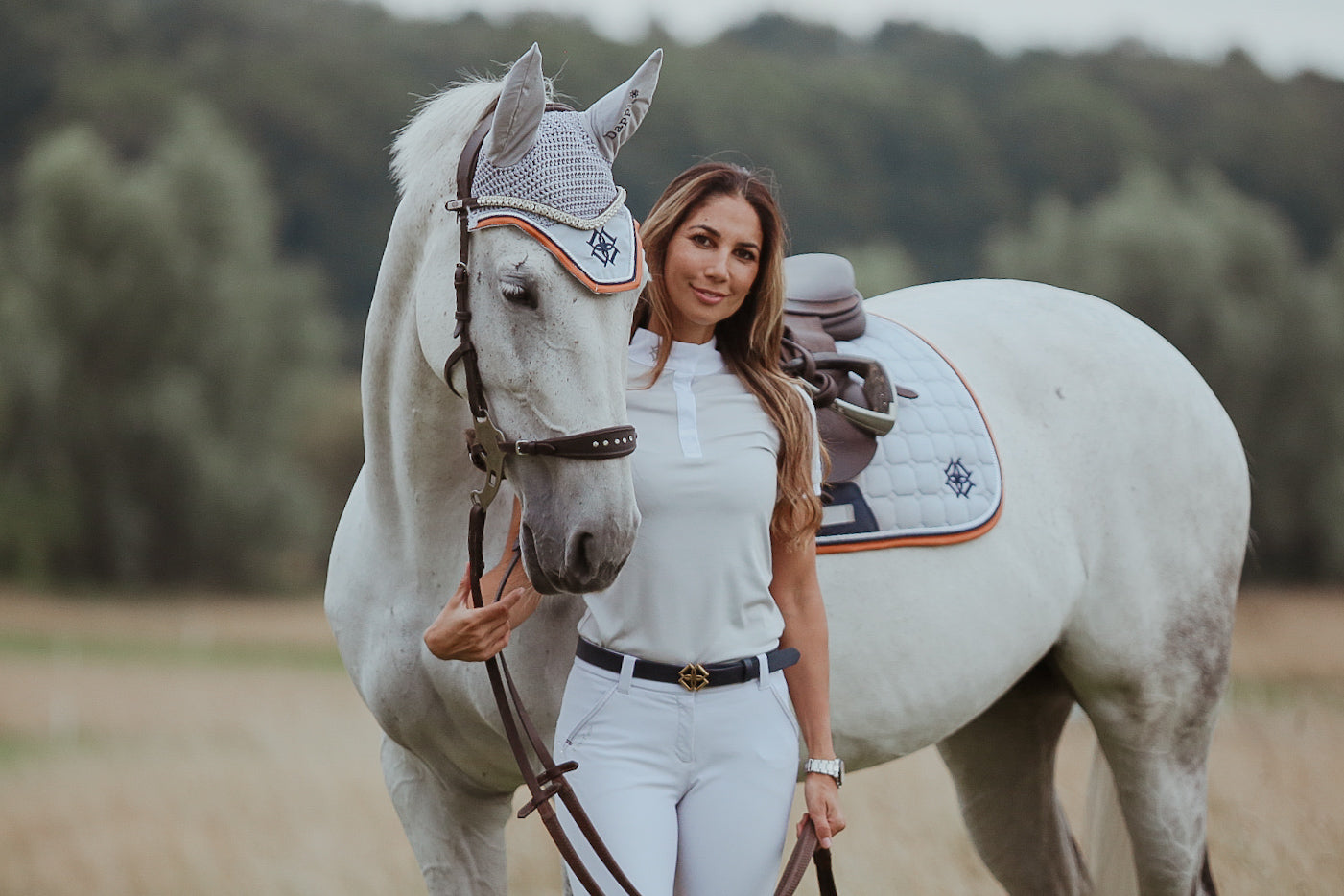 Dapple Equestrian Cloud Grey Set, horse rider wearing cloud grey show shirt, and white horse wearing cloud grey fly veil and saddle pad