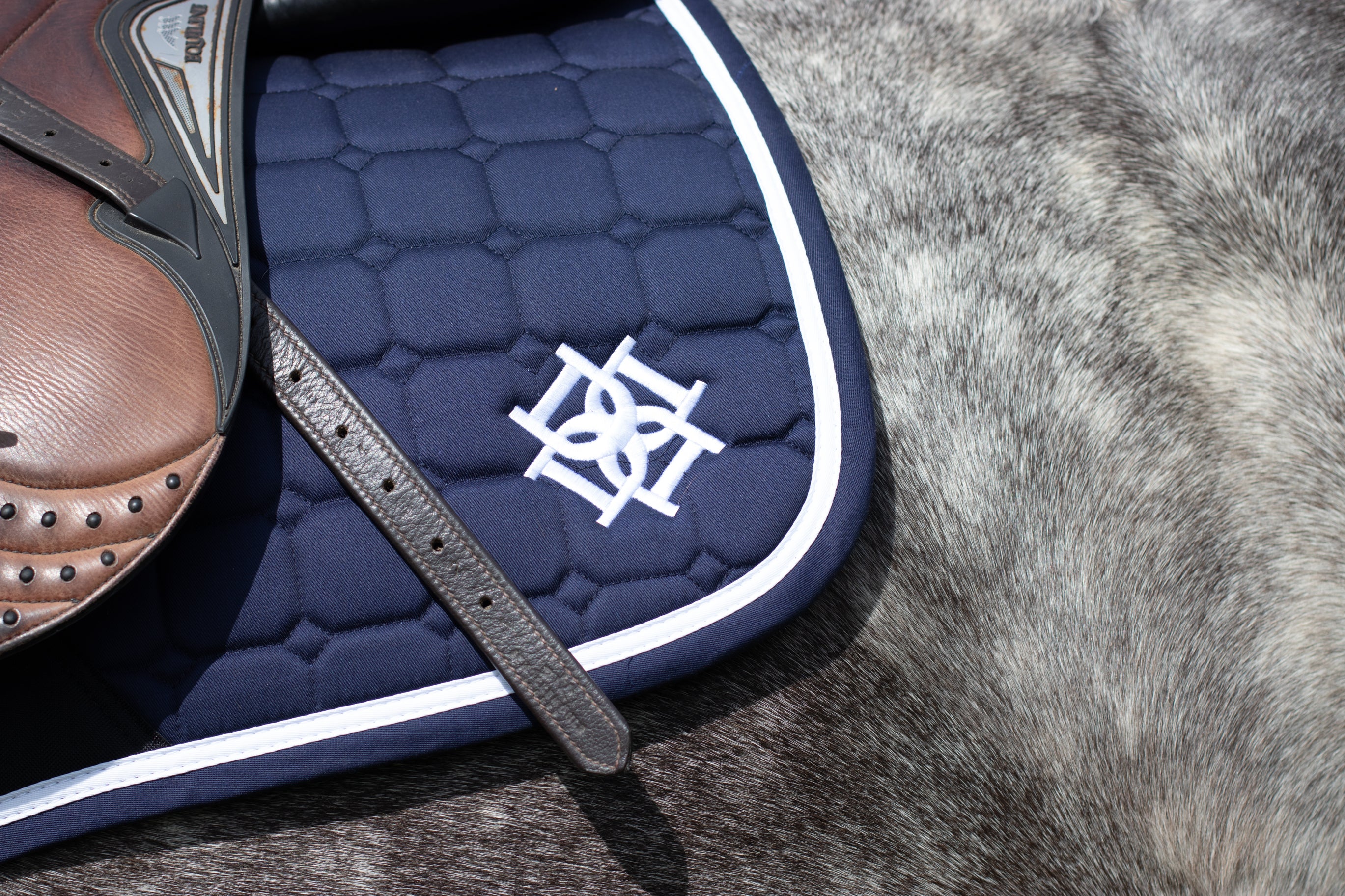 Close up photo of the Dapple Logo on Navy Saddle Pad