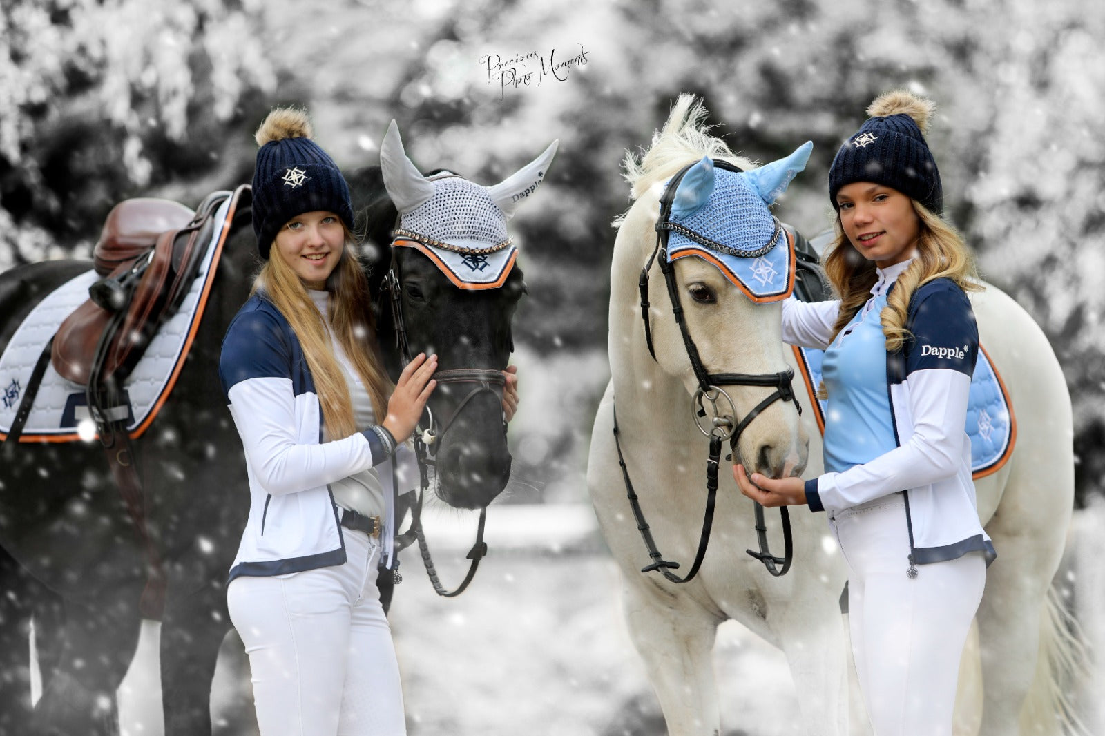 Two Dapple Riders and  Two Horses in Snow. Both riders are wearing Dapple Training Jackets and Bobble Hats. Black horse is wearing Cloud Grey Saddle Pad and Ear Bonnet. White Horse wearing Sky Blue Saddle Pad and Ear Bonnet. photo by Precious Photo Moments Photography