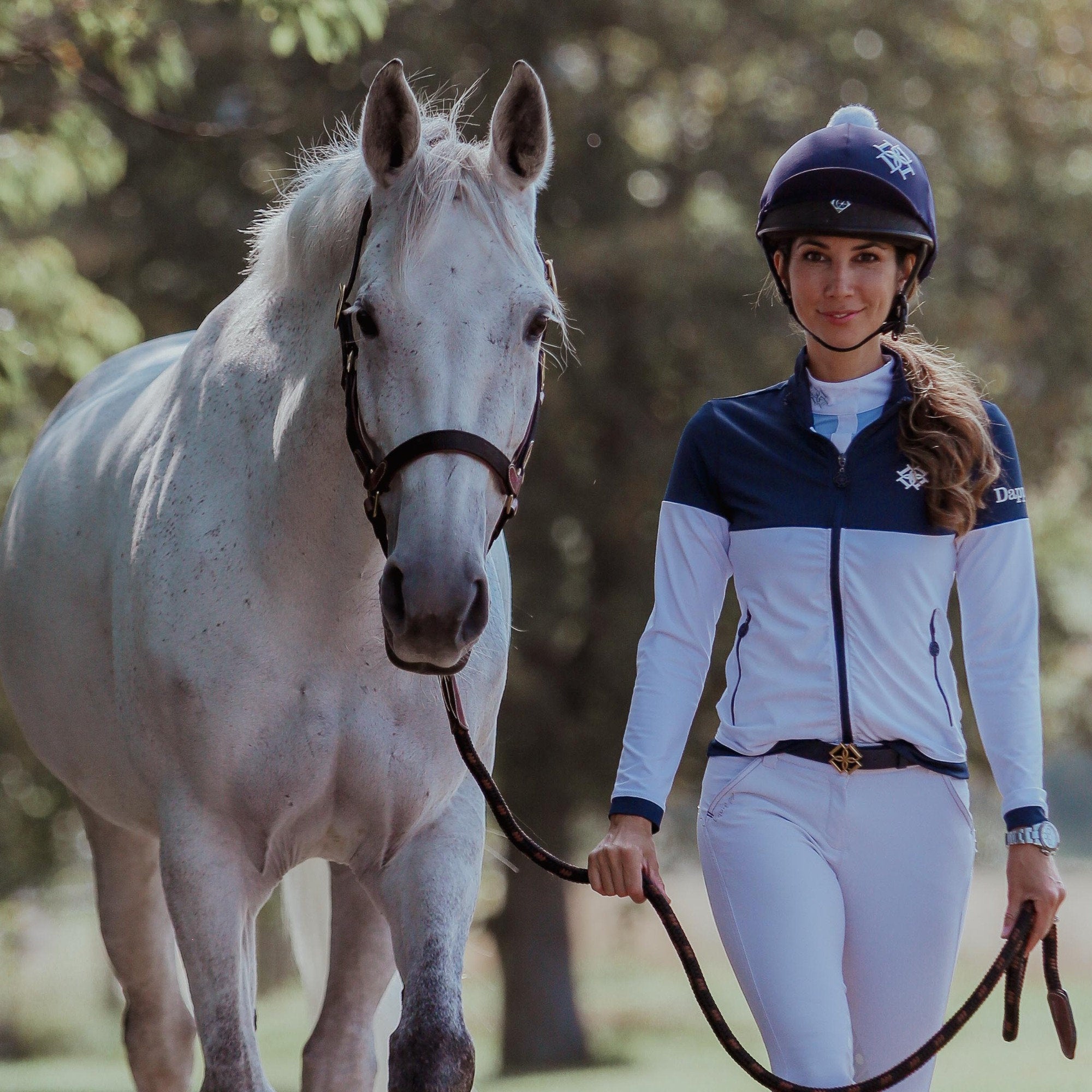 Dapple rider wearing Training Jacket and Dapple Belt. White Horse wearing head collar and lead