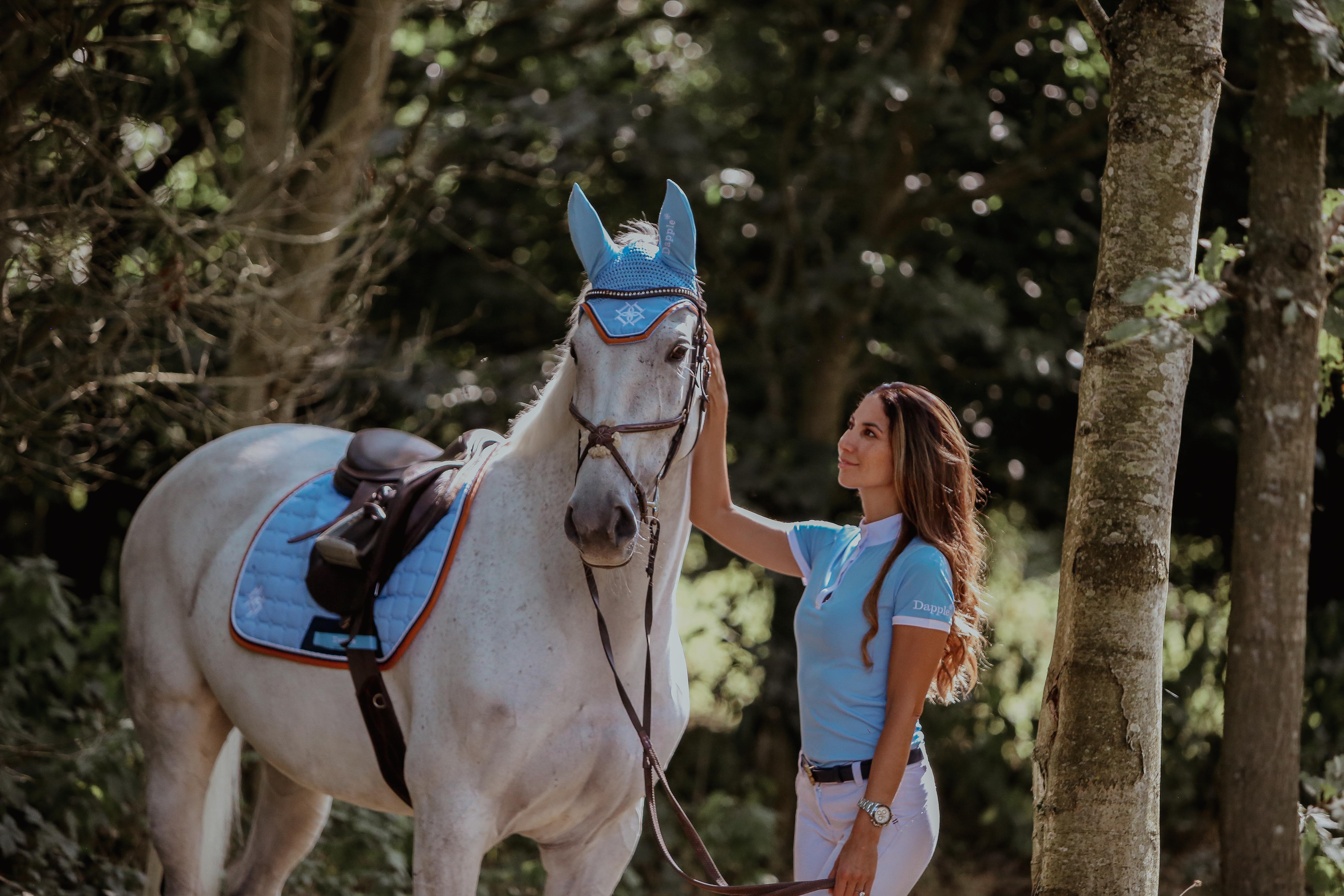 Horse rider with horse wearing Sky Blue Show Shirt and horse wearing matching sky blue saddle pad and ear bonnet